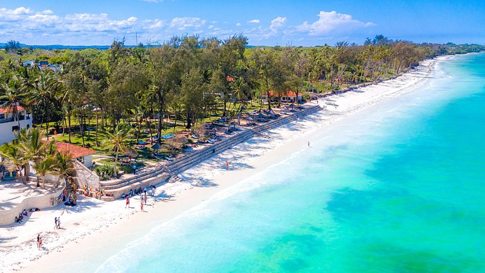 Diani Beach — sandy beach with chairs and thatched huts on the Kenya Coast